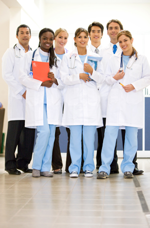 Group of seven young adults (healthcare professionals) smiling in a group picture 