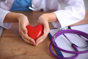 Female Medical Professional holding a heart shaped object with both hands 