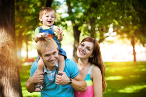 Young parents with their baby on a walk in the park