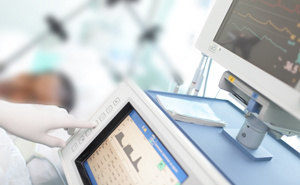 Male patient lying in a swing bed next to a heart monitor machine