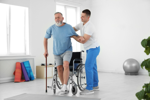 Rehabilitation doctor helping patient in physical therapy 